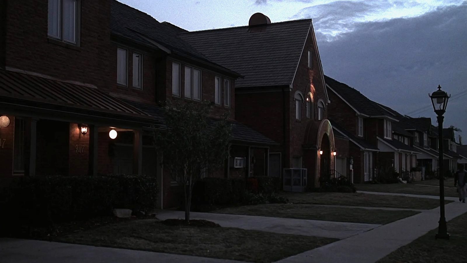 North Texas street at dusk with brick homes and dark shingle roofs