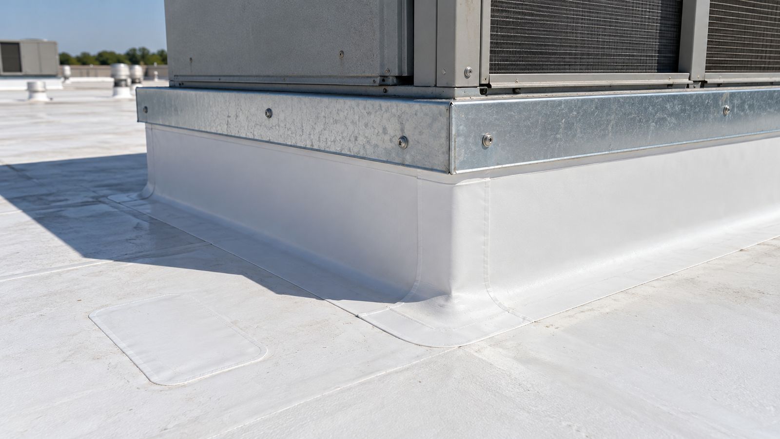 New membrane flashing and metal counterflashing at a rooftop unit curb