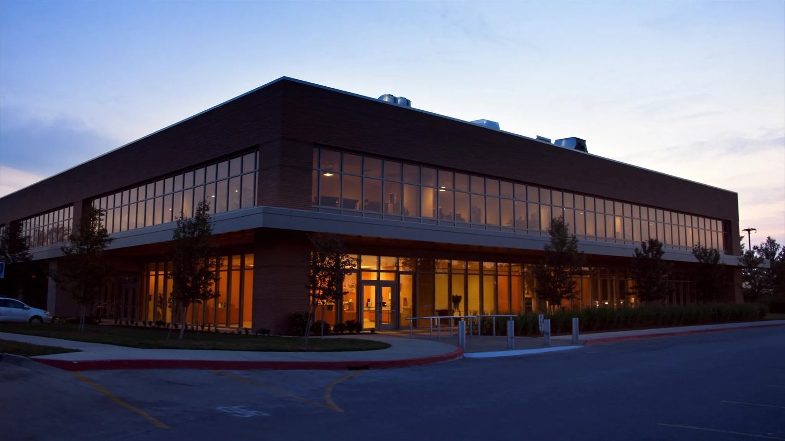 Two-story office building at dusk with a clean metal-coped roof edge